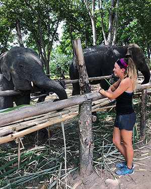 Rachel Fuller '19 (Biology) with elephants in Khun Chai Tong, Thailand, July 2018. Anonymous photographer.