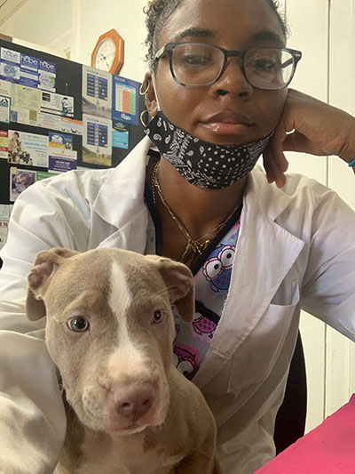 Perkins at Brentwood Animal Hospital, Brentwood, Maryland. In this picture, she is caring for a puppy who was scared of being in the cage by himself while trying to analyze the blood results of another patient. Selfie taken on August 8, 2020.