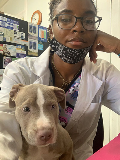 Perkins at Brentwood Animal Hospital, Brentwood, Maryland. In this picture, she is caring for a puppy who was scared of being in the cage by himself while trying to analyze the blood results of another patient. Selfie taken on August 8, 2020. Perkins at Brentwood Animal Hospital, Brentwood, Maryland. In this picture, she is caring for a puppy who was scared of being in the cage by himself while trying to analyze the blood results of another patient. Selfie taken on August 8, 2020.