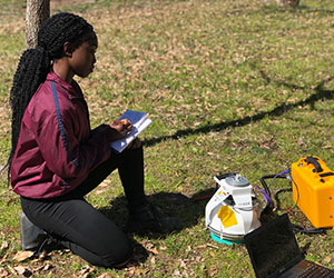Mayanni McCourty recording data on CO2 content using a LI-COR, Virginia Wesleyan Campus, spring 2019.