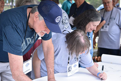 Alumni sign scroll during Spring Alumni Weekend.
