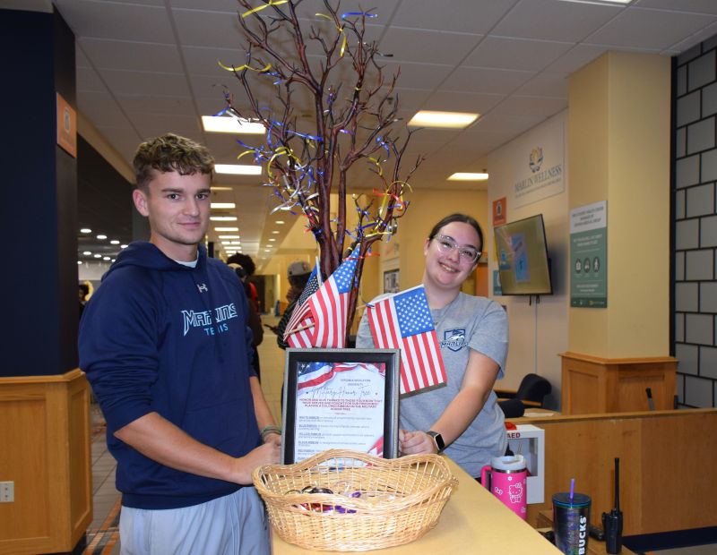 Jed Platts '27 and Haydn Hollowell '29 tie ribbons on VWU's Honor Tree