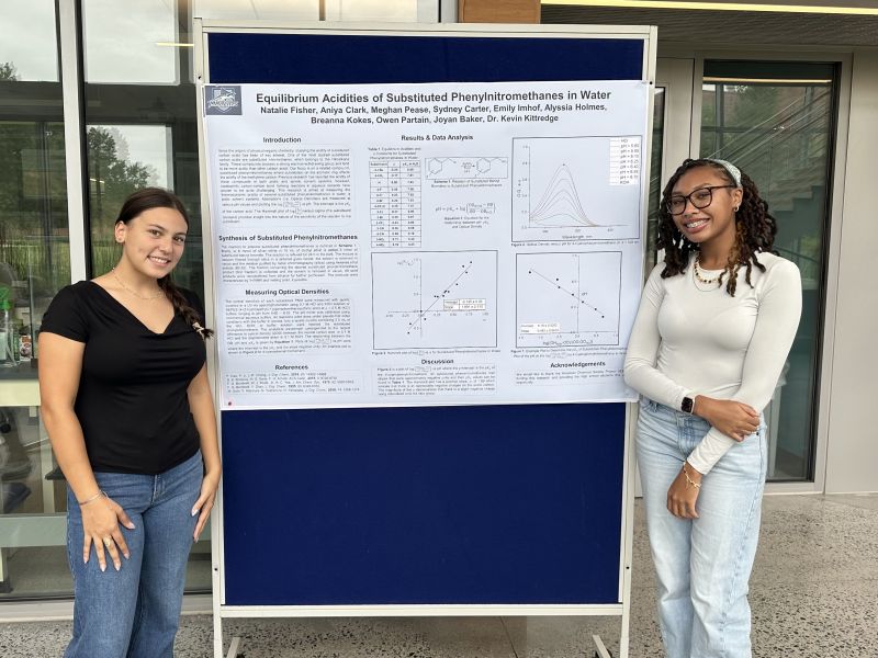 Project SEED students Natalie Fisher and Aniya Clark with their research poster